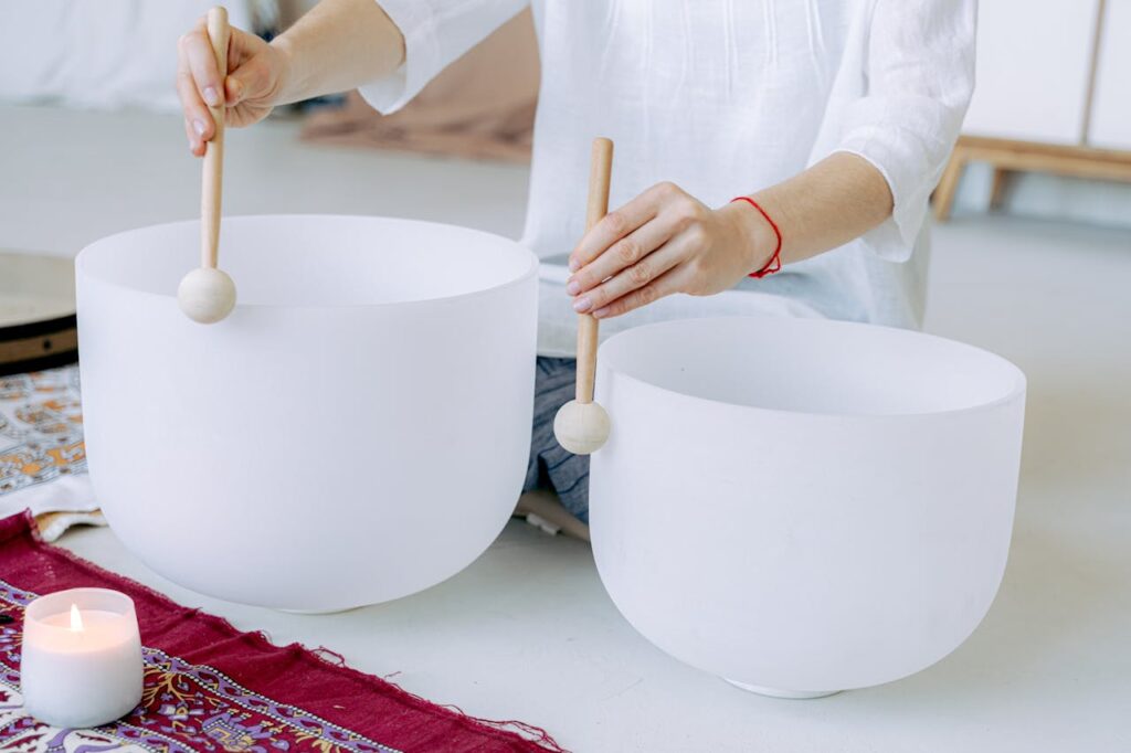 Close-up of hands playing crystal singing bowls for sound healing and meditation.