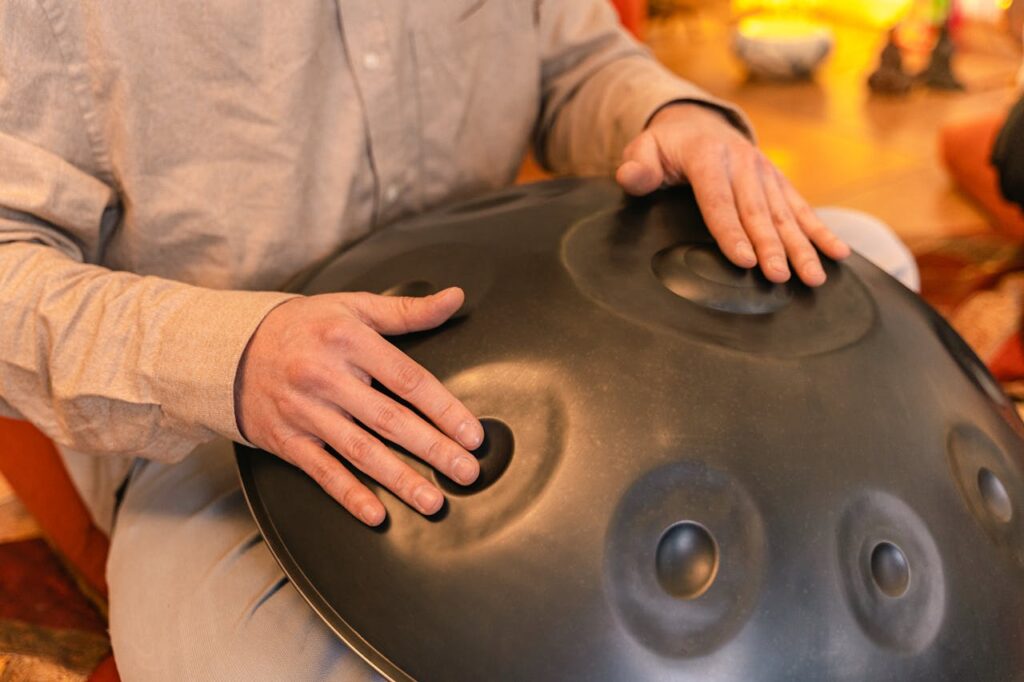 A person plays a handpan instrument, focusing on relaxation and zen vibes indoors.